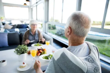 Older man and woman sitting at a dining table in a restaurant.